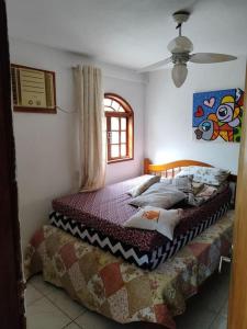 ein Schlafzimmer mit einem Bett und einem Fenster in der Unterkunft Casa para temporada em São Pedro da Aldeia Até 6 pessoas in São Pedro da Aldeia