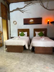 dwa łóżka siedzące w pokoju z w obiekcie Gading Tree House w mieście Nusa Penida
