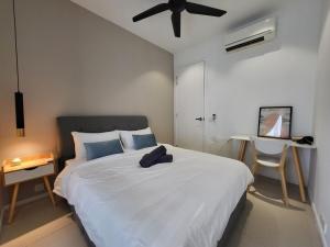 - une chambre avec un lit blanc et un ventilateur de plafond dans l'établissement Arcoris Mont Kiara, à Kuala Lumpur