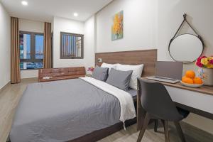 Schlafzimmer mit einem Bett und einem Schreibtisch mit einem Laptop in der Unterkunft TIDITEL Hotel and Apartment in Đà Nẵng