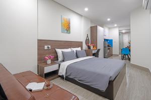 ein Schlafzimmer mit einem großen Bett und einem Sofa in der Unterkunft TIDITEL Hotel and Apartment in Đà Nẵng