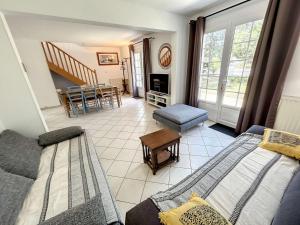 a living room with a couch and a table at Villa 5 pièces avec jardin, à 400m de la plage et 600m des commerces, wifi et barbecue inclus - FR-1-361-20 in Jullouville-les-Pins