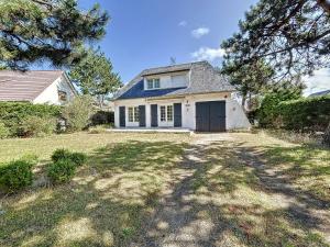 a white house with a garage and a yard at Villa 5 pièces avec jardin, à 400m de la plage et 600m des commerces, wifi et barbecue inclus - FR-1-361-20 in Jullouville-les-Pins
