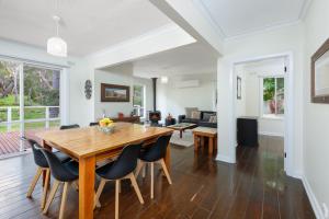 a dining room and living room with a wooden table and chairs at Serenity Halls Gap 2 Absolute NP Frontage in Halls Gap