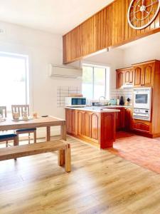 a large kitchen with wooden cabinets and a table at Luxury Hobart City Fringe Home in Hobart