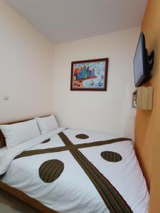 a bedroom with a bed with a picture on the wall at The Cabin Hotel Sumberan in Yogyakarta +5 photos