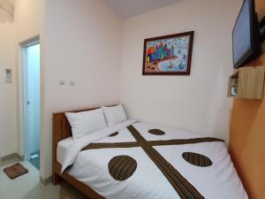 a bedroom with a bed with a picture on the wall at The Cabin Hotel Sumberan in Yogyakarta