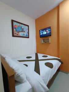 a bedroom with a bed with a tv on the wall at The Cabin Hotel Sumberan in Yogyakarta