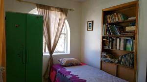 a bedroom with a green cabinet and a window at Preciosa casa colonial in Quito