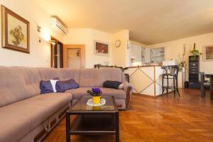 ein Wohnzimmer mit einem Sofa und einem Tisch in der Unterkunft Apartment Ingrid in Pula
