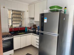 uma cozinha com um frigorífico de aço inoxidável em Casa de praia com piscina em Solemar