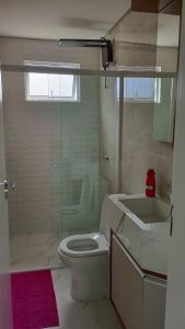 a bathroom with a toilet and a sink and a shower at Encantador Apto NOVO, climatizado e confortável - 200m das Thermas in Piratuba
