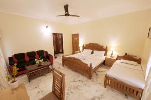 a hotel room with two beds and a couch at Metropolitan Serviced Villa in Cochin