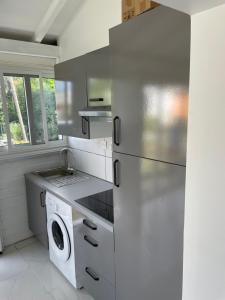 een keuken met een koelkast en een wasmachine bij LE MANGO 'Lodge in Saint-François