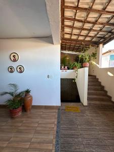 einen Flur mit Treppen und Topfpflanzen an der Wand in der Unterkunft Residencial Edite Bulhões in Guaibim
