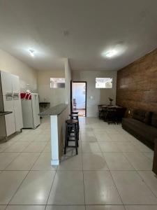 a kitchen and living room with a couch and a table at Residencial Edite Bulhões in Guaibim