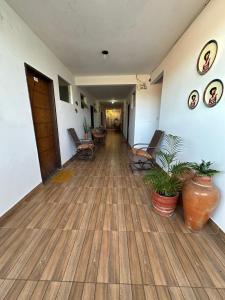 un couloir vide d'un hôpital avec des chaises et des plantes dans l'établissement Residencial Edite Bulhões, à Guaibim