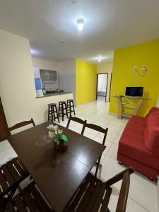 ein Wohnzimmer mit einem Tisch und einem roten Sofa in der Unterkunft Residencial Edite Bulhões in Guaibim