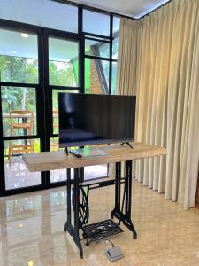 a desk with a flat screen tv on top of it at Sampai Villa Ruang Tepi in Yogyakarta