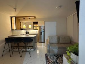 een keuken en een woonkamer met een bar en een bank bij Apartamento cerca al aeropuerto BILBAO in Cúcuta