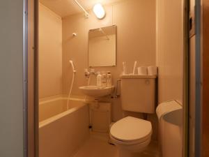 a bathroom with a toilet and a sink and a tub at Tabist A Mirai Oji in Tokyo