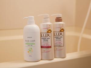 three bottles of body wash sitting on a shelf in a bathroom at Tabist A Mirai Oji in Tokyo