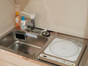 a kitchen counter with a sink and a sink at Tabist A Mirai Oji in Tokyo