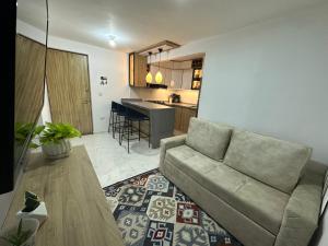 a living room with a couch and a kitchen at Apartamento cerca al aeropuerto BILBAO in Cúcuta