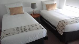 duas camas sentadas uma ao lado da outra num quarto em Pumicestone Blue Resort em Caloundra