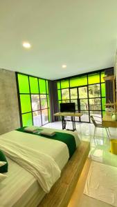 a bedroom with a large bed with green windows at Sampai Villa Ruang Tepi in Yogyakarta