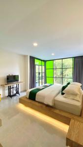 a bedroom with a large bed with a green wall at Sampai Villa Ruang Tepi in Yogyakarta