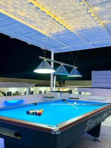 un tavolo da biliardo in una stanza con due luci di Issa's Haven Resort a Look