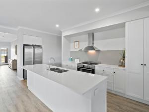 a white kitchen with a large white counter top at Sunsets by the Lake in Yarrawonga