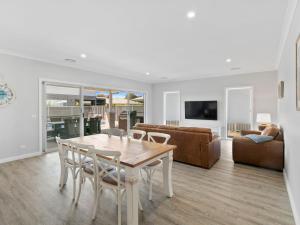 a living room with a table and chairs and a couch at Sunsets by the Lake in Yarrawonga