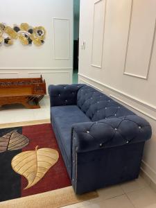 Sofá azul en la sala de estar con alfombra en Wan Homestay en Sungai Petani
