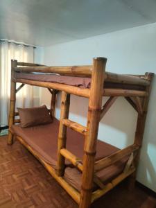 a wooden bunk bed in a room with at Beach Front Calatagan Apartelle in Calatagan