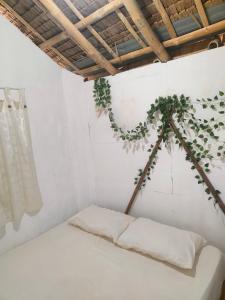 a bed in a room with a plant at Beach Front Calatagan Apartelle in Calatagan