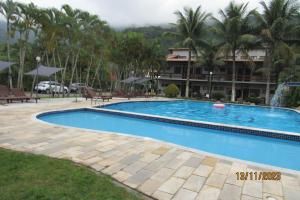 a swimming pool in front of a hotel at Maresias - Flat confortável in Maresias