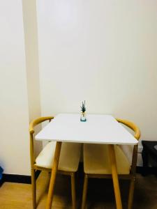einen weißen Tisch und Stühle mit Vase drauf in der Unterkunft 1 Bedroom with Balcony in Manila