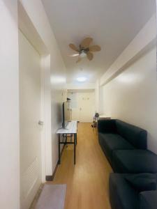 - un salon avec un canapé et un ventilateur de plafond dans l'établissement 1 Bedroom with Balcony, à Manille