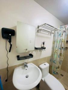 ein Badezimmer mit einem weißen WC und einem Waschbecken in der Unterkunft 1 Bedroom with Balcony in Manila