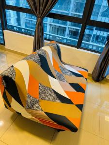 a colorful blanket sitting on top of a chair at Arte Plus KL By Rainbow in Kuala Lumpur