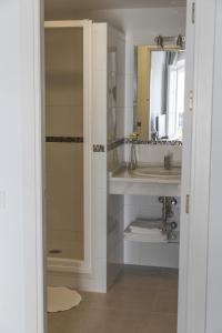 Un baño con lavabo, ducha y espejo. en Apartamentos Casamonteymar Bas-Ser, en Vejer de la Frontera 25 fotos más
