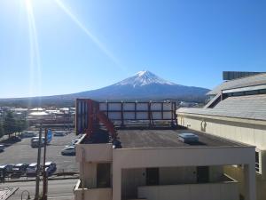 uma vista para uma montanha a partir de um edifício com um edifício em Plaza Inn Kawaguchiko em Fujikawaguchiko
