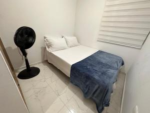 a small bedroom with a bed and a fan at Apartamento cerca al aeropuerto BILBAO in Cúcuta