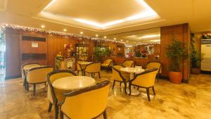 マニラにあるAloha Hotel Roxas Boulevard Manilaのテーブルと椅子が備わるレストラン