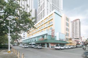 マニラにあるAloha Hotel Roxas Boulevard Manilaの高い建物が立ち並ぶ路上駐車の建物