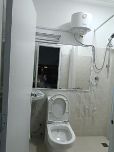 een badkamer met een wit toilet en een spiegel bij Ontrack Travel Transit Hotel in Male City