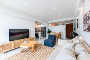 een woonkamer met een bank en een tafel bij Riverside 2 Bedroom apartment with parking in Brisbane