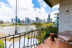 a balcony with a view of a river and a city at Riverside 2 Bedroom apartment with parking in Brisbane